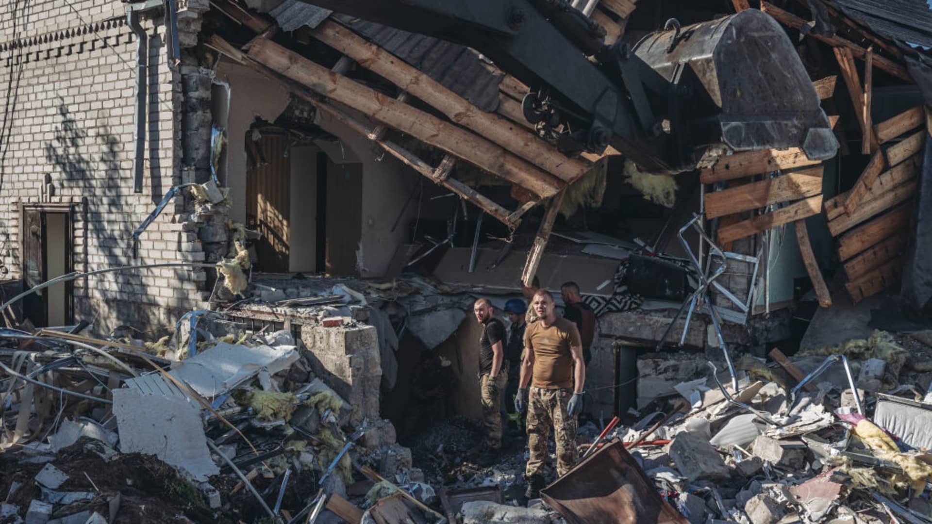 Ukrainian emergency service workers and military personnel try to get bodies out of a house that was shelled in Sloviansk, Ukraine, on July 19, 2022.