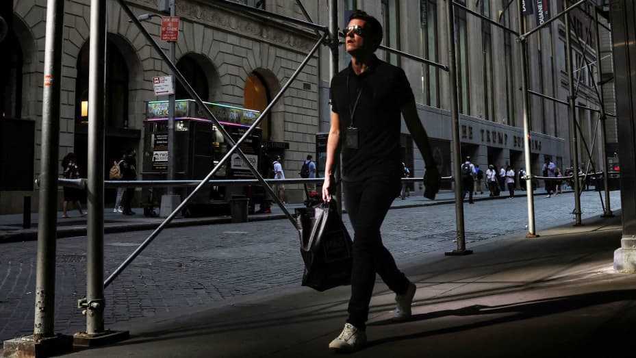 A man walks on Wall St. during the morning commute, as the city deals with record temperatures and the excessive heat, in New York, July 20, 2022.