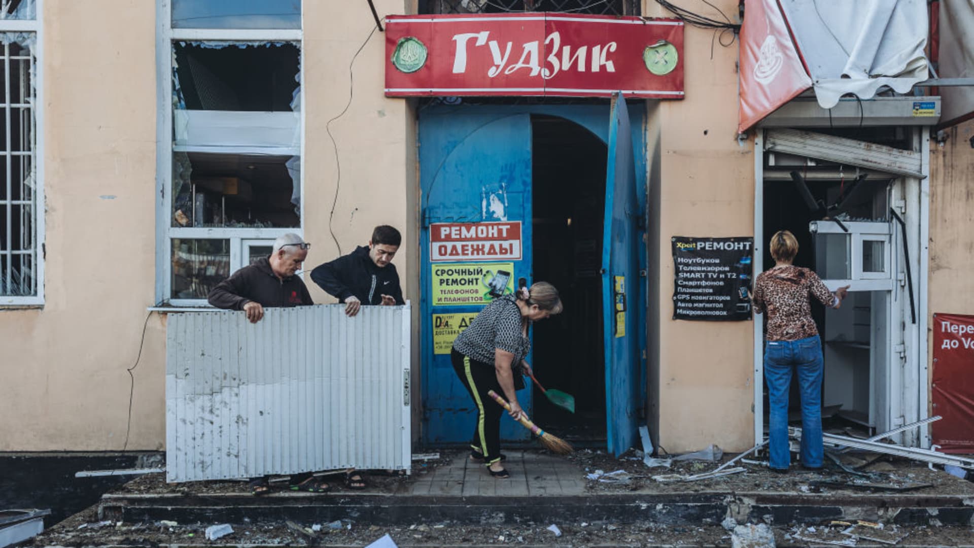 Locals clean the entrance to their shop at the Bakhmut market after it was shelled by the Russian army, in the city of Bakhmut, Donetsk Oblast of Ukraine on July 21, 2022.