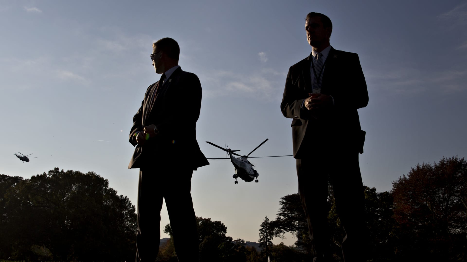 U.S. Secret Service agents stand watch as Marine One, with U.S. President Donald Trump on board, departs the South Lawn of the White House in Washington, D.C., U.S., on Friday, Nov. 3, 2017.