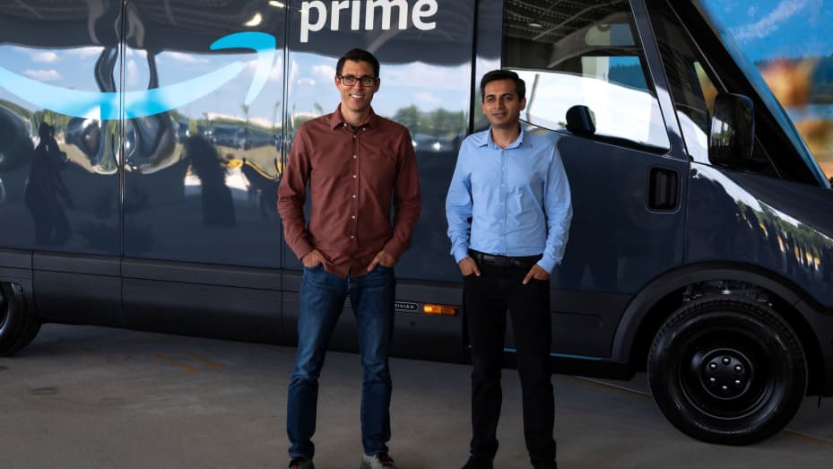 Rivian CEO RJ Scaringe and Udit Madan stand in front of the new Amazon EV van powered by Rivian. Amazon and Rivian unveil their final custom Electric Delivery Vehicles (EDV) to begin using them for customer deliveries, in Chicago, Illinois, July 21, 2022.