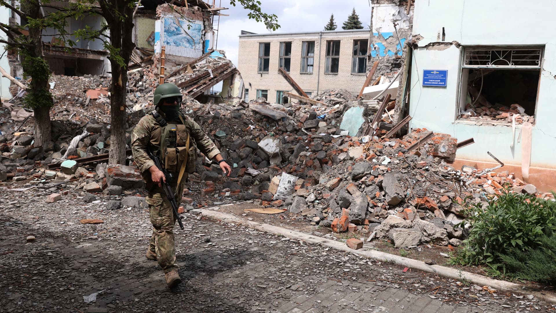A Ukrainian serviceman passes by destroyed buildings in the Ukrainian town of Siversk, Donetsk region on July 22, 2022 amid the Russian invasion of Ukraine. 