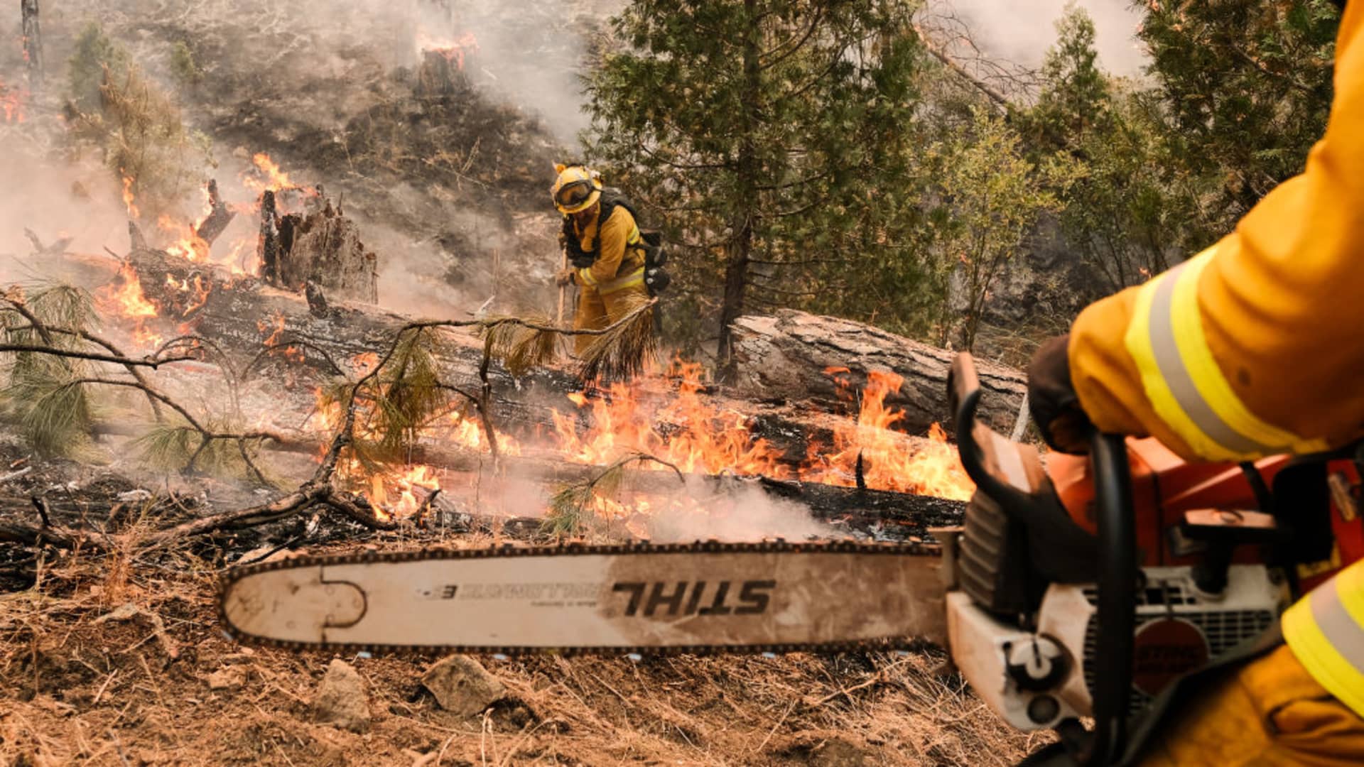 Firefighters work to contain a fire in order to save a structure located near Jerseydale Road during the Oak Fire in Mariposa County, California, US, on Sunday, July 24, 2022.