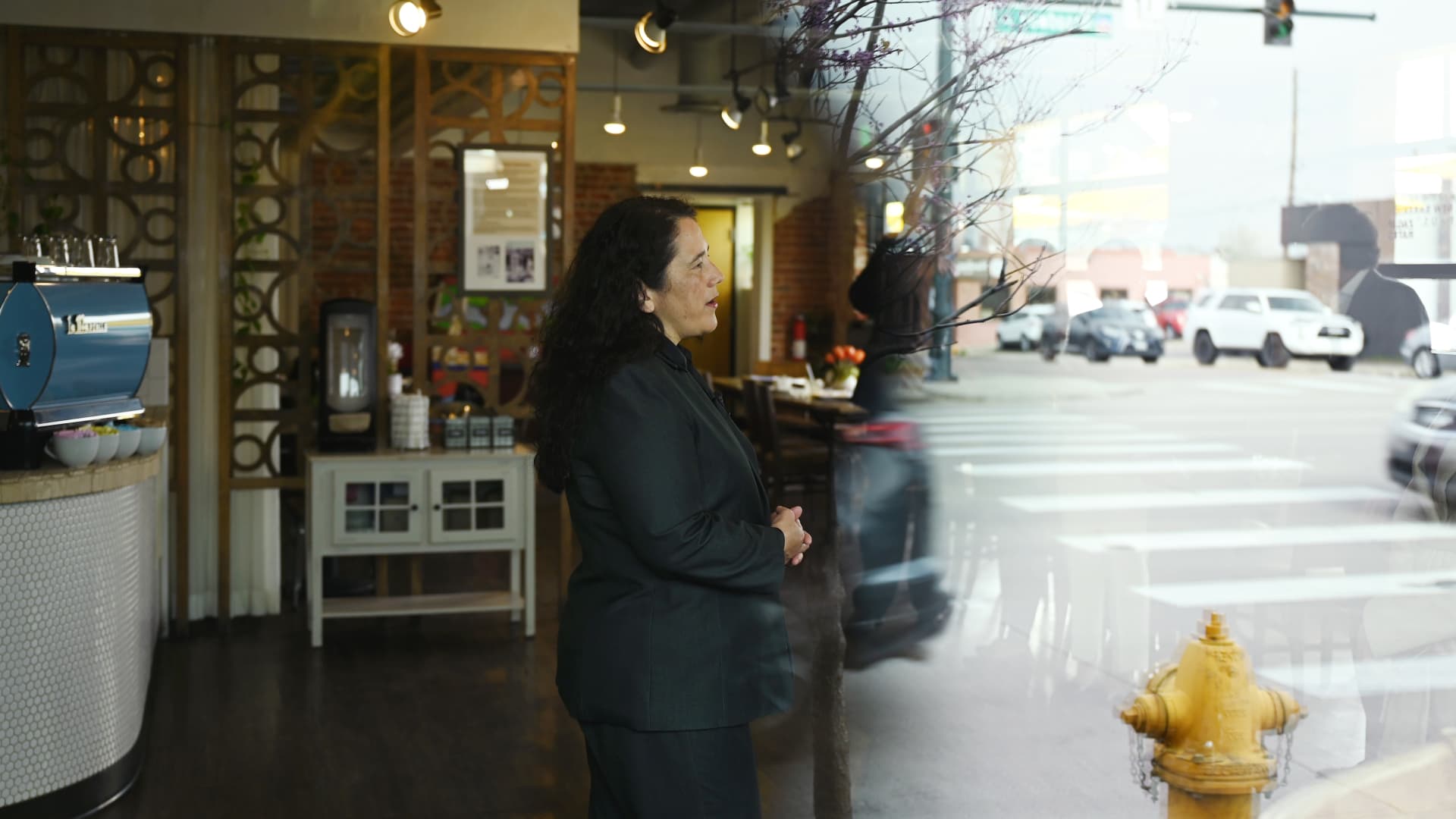 Seen through the window of Maria Empanada on South Broadway, Small Business Administration Administrator Isabella Guzman does an interview with a local television station on May 3, 2022 in Denver, Colorado.