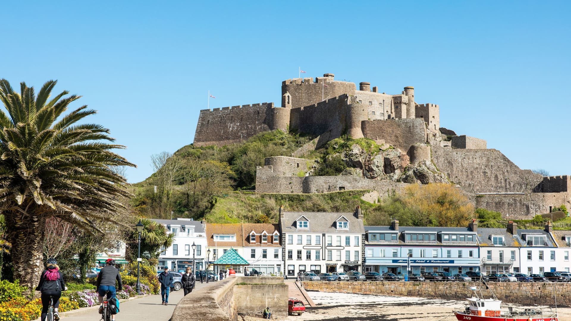 The 800-year-old Mont Orgueil Castle in Jersey, with The Moorings (blue building) in the foreground.