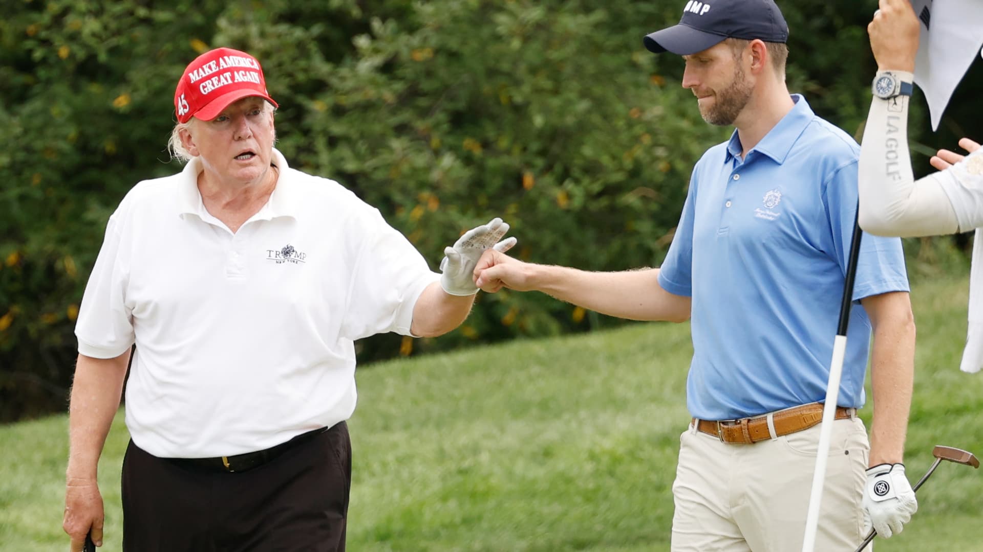 Former U.S. President Donald Trump and son Eric Trump react to his putt on the 14th green during the pro-am prior to the LIV Golf Invitational - Bedminster at Trump National Golf Club Bedminster on July 28, 2022 in Bedminster, New Jersey.
