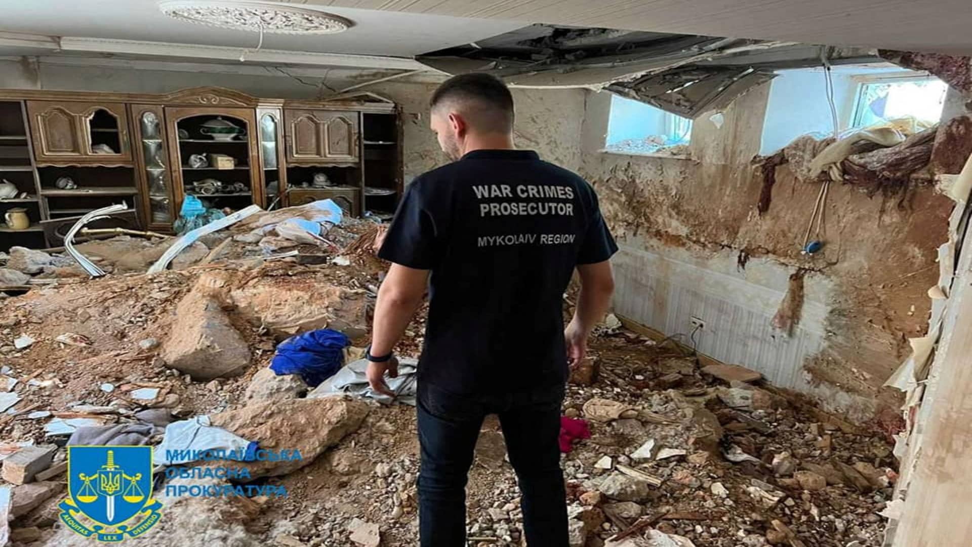 A war crimes prosecutor examines the damage in a destroyed building, as Russia's attack on Ukraine continues, following shelling in Mykolaiv, Ukraine, in this handout picture released on July 31, 2022.