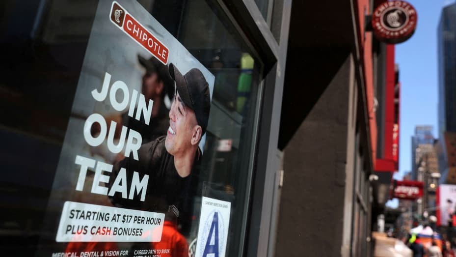 A sign for hire is posted on the window of a Chipotle restaurant in New York, April 29, 2022.