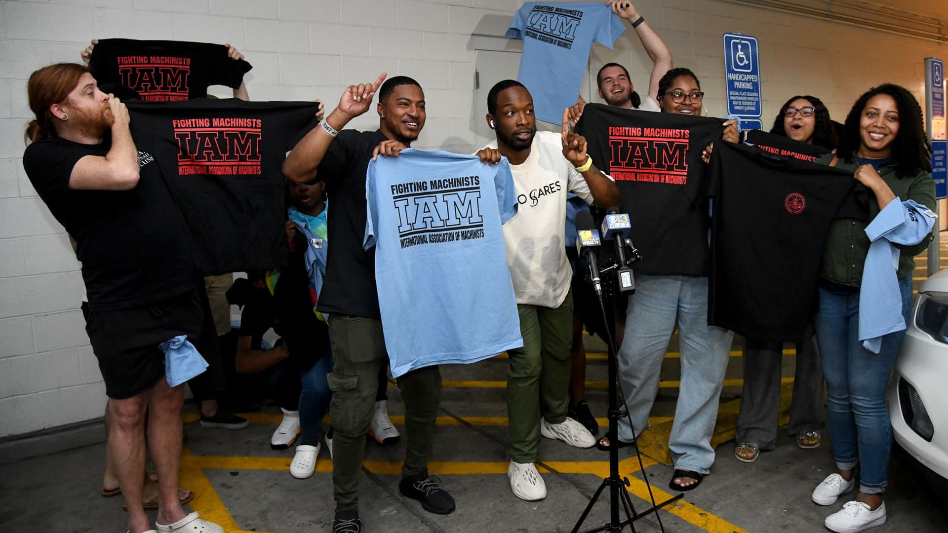 Apple store workers in Towson, Maryland, hold their new union t-shirts on June 18, 2022, after their store employees decided to join the International Association of Machinists Union. Theirs is the first Apple store in the U.S. to vote for union representation.