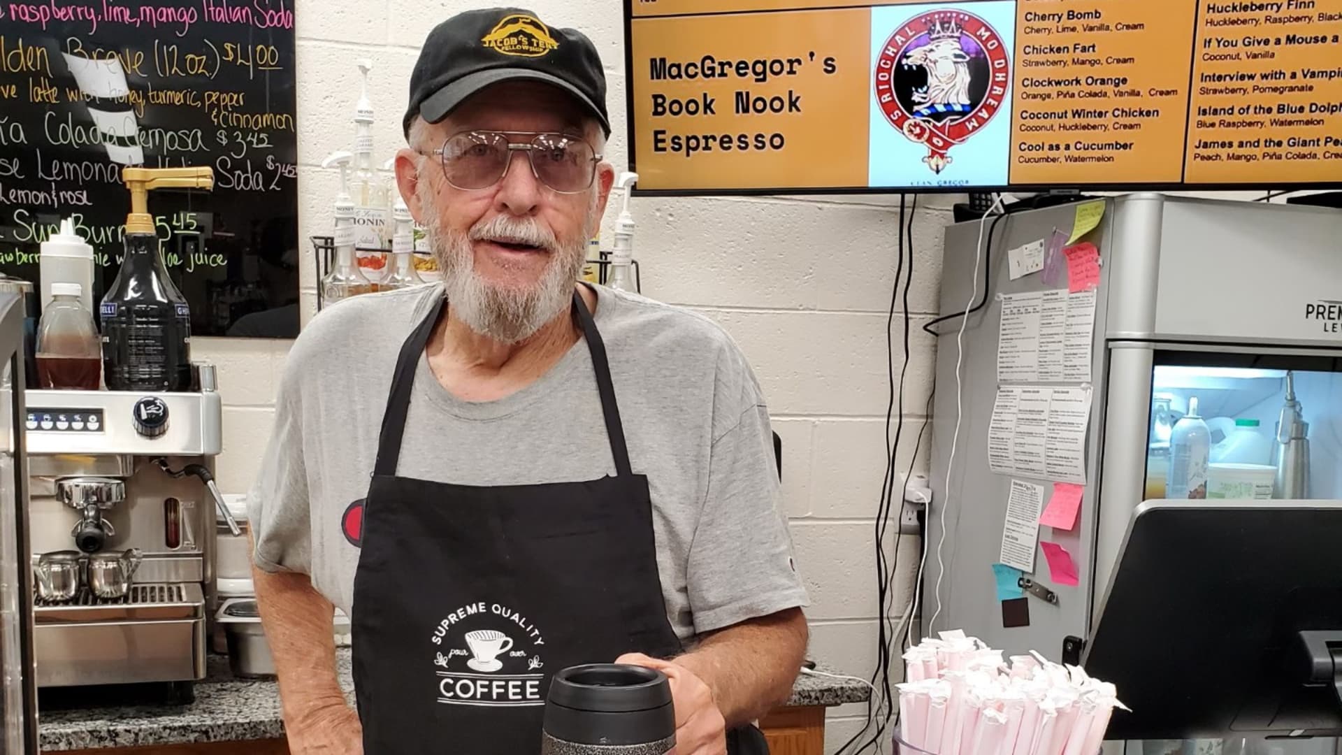 Gibbons working behind the counter in his bookstore's coffee bar. Since opening the bookstore in December 2020, he says the business is almost profitable. For now, it's supported by his JustAnswer income.