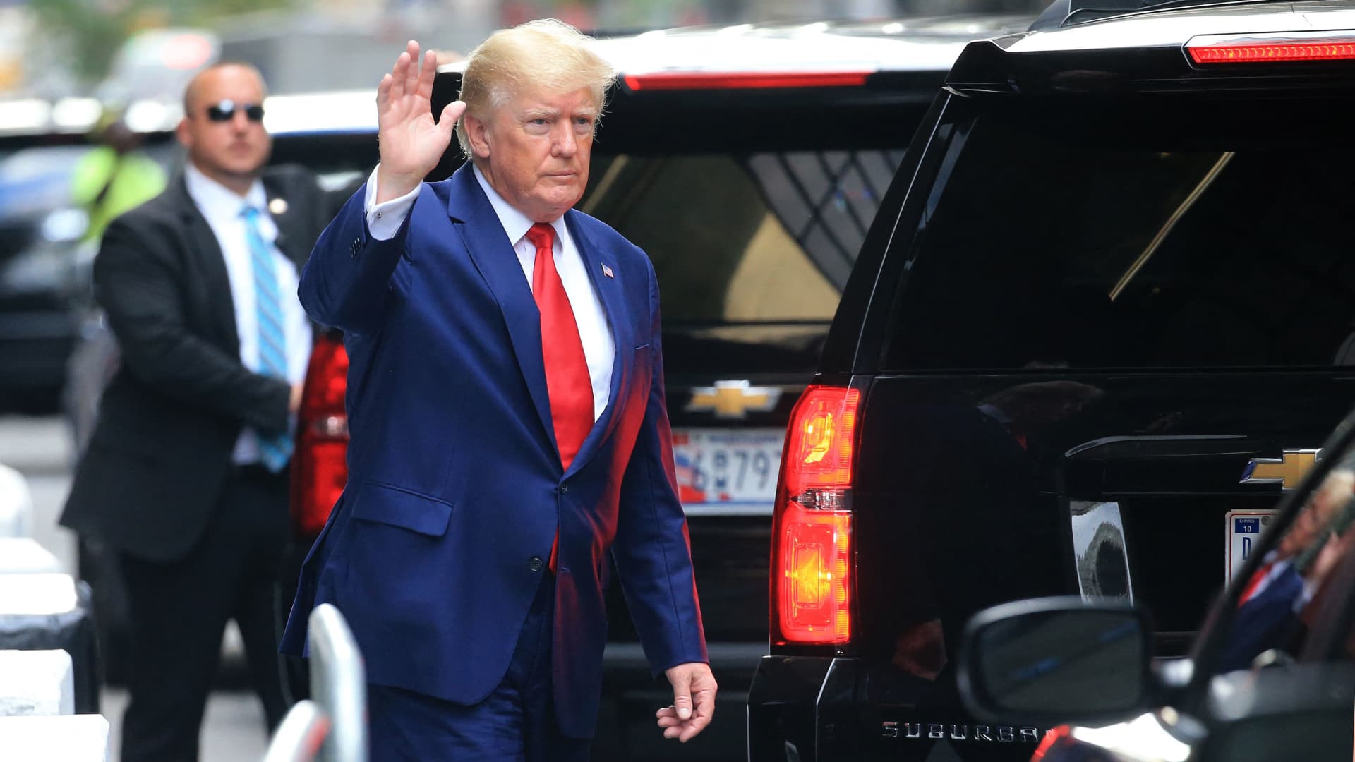 Former US President Donald Trump waves while walking to a vehicle in New York City on August 10, 2022. Donald Trump on Wednesday declined to answer questions under oath in New York over alleged fraud at his family business, as legal pressures pile up for the former president whose house was raided by the FBI just two days ago.