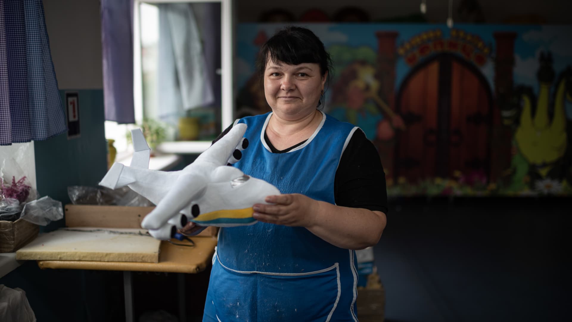 Nina, a worker of the Kopytsia tory factory, poses for a portrait with the Mriia airplane toy on August 10, 2022 in Nizhyn, Ukraine. 