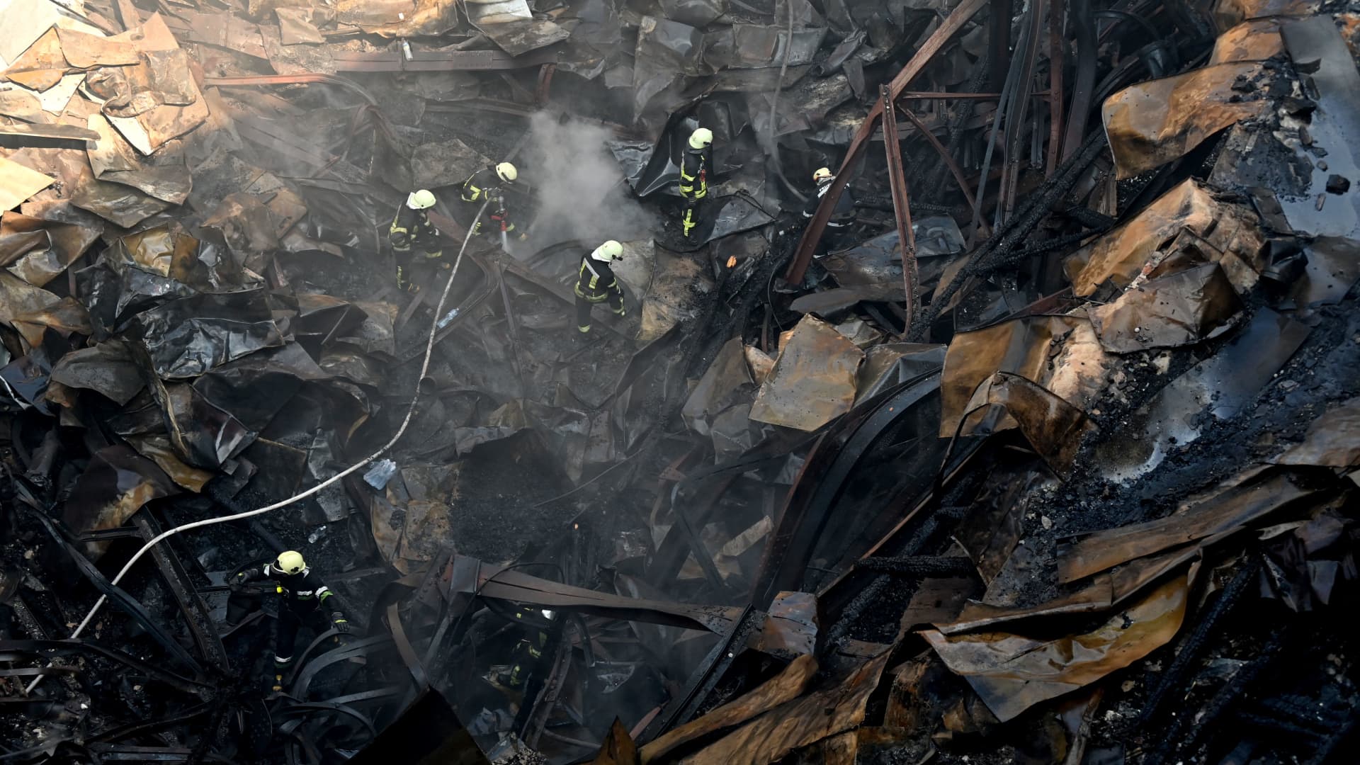 Firefighters respond in the rubble of the Culture Palace destroyed by a Russian missile strike in the second-largest Ukrainian city of Kharkiv, on Aug. 18, 2022.