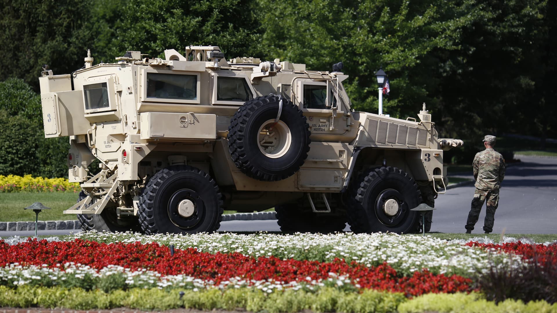A solider stands in front of a Mine-Resistant Ambush Protected (MRAP) armored vehicle outside The Greenbrier resort ahead of a Salute to Service dinner with U.S. President Donald Trump, not pictured, in White Sulphur Springs, West Virginia, U.S., on Tuesday, July 3, 2018.