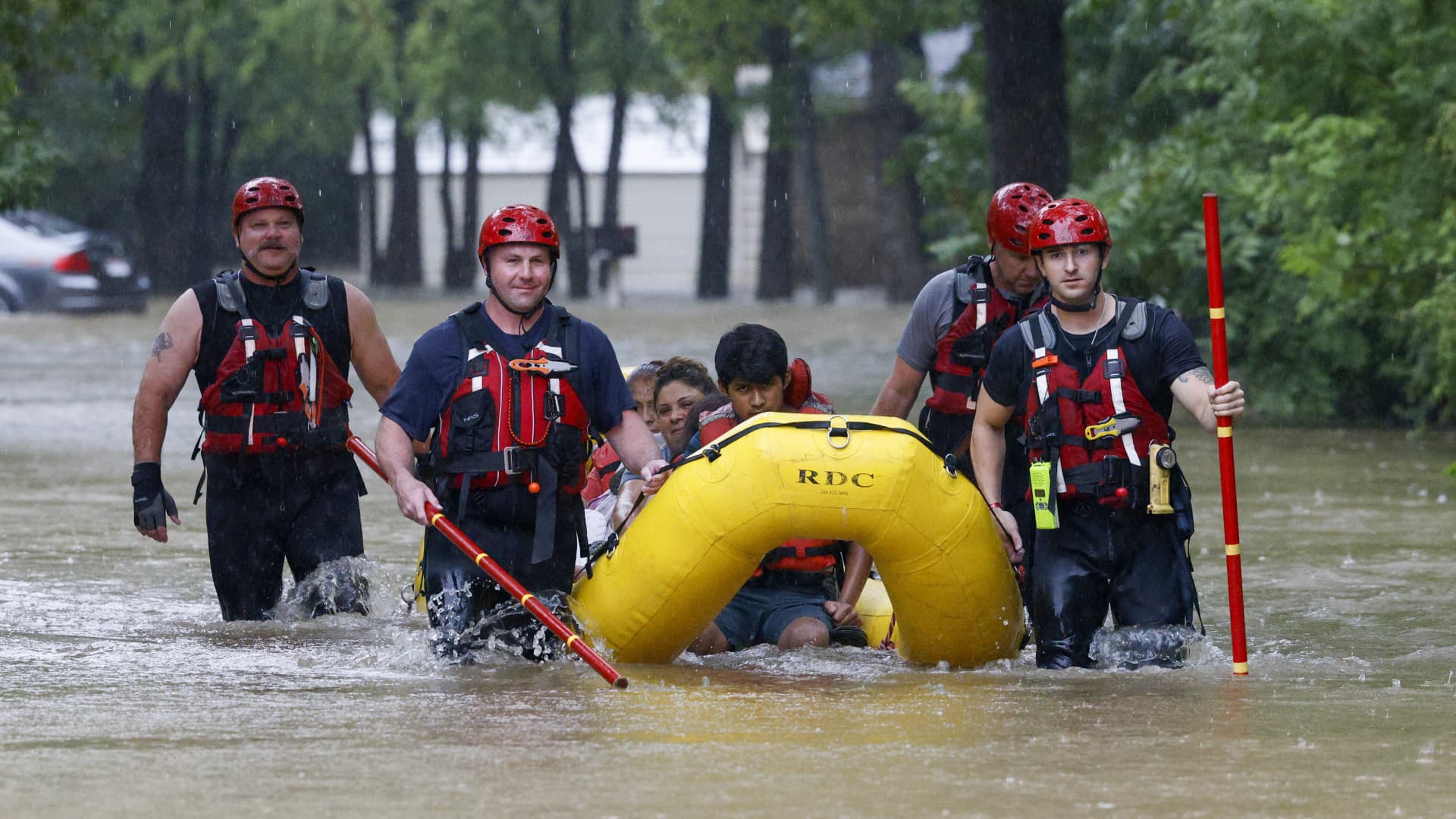 Members of the Balch Springs Fire Department bring a family of four by boat to higher ground after rescuing them from their home along Forest Glen Lane in Balch Springs, Texas, Monday, Aug. 22, 2022.