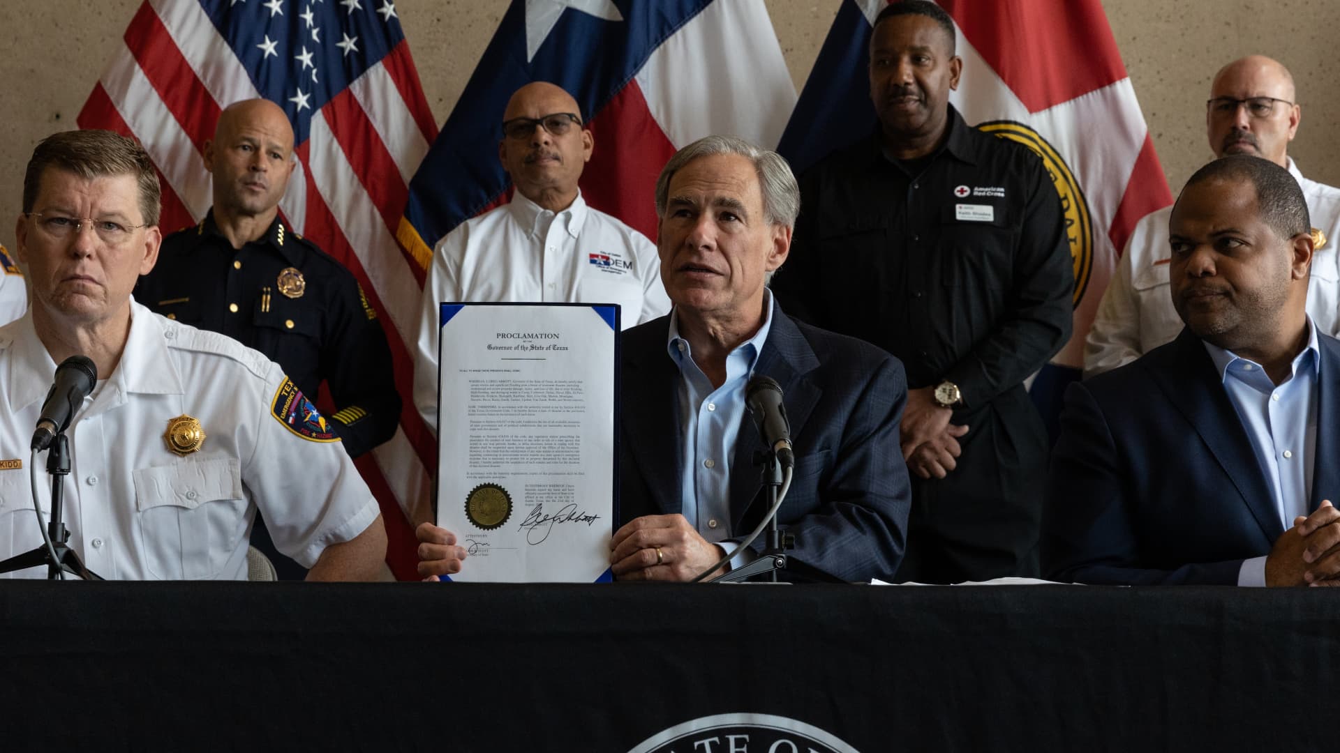 Greg Abbott, governor of Texas, holds up a signed disaster declaration during a news conference in Dallas, Texas, US, on Tuesday, Aug. 23, 2022.