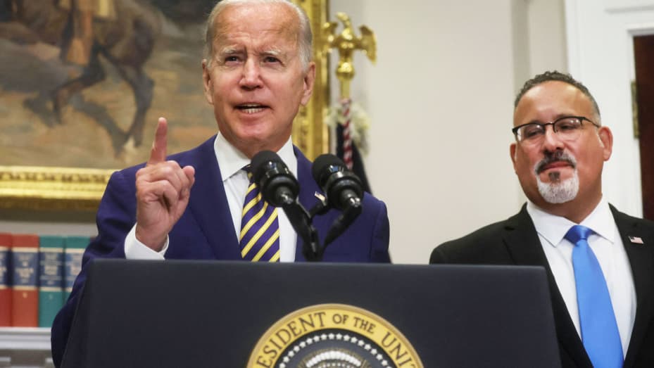 U.S. President Joe Biden is flanked by U.S. Secretary of Education Miguel Cardona as he speaks about administration plans to forgive federal student loan debt during remarks in the Roosevelt Room at the White House in Washington, U.S., August 24, 2022.
