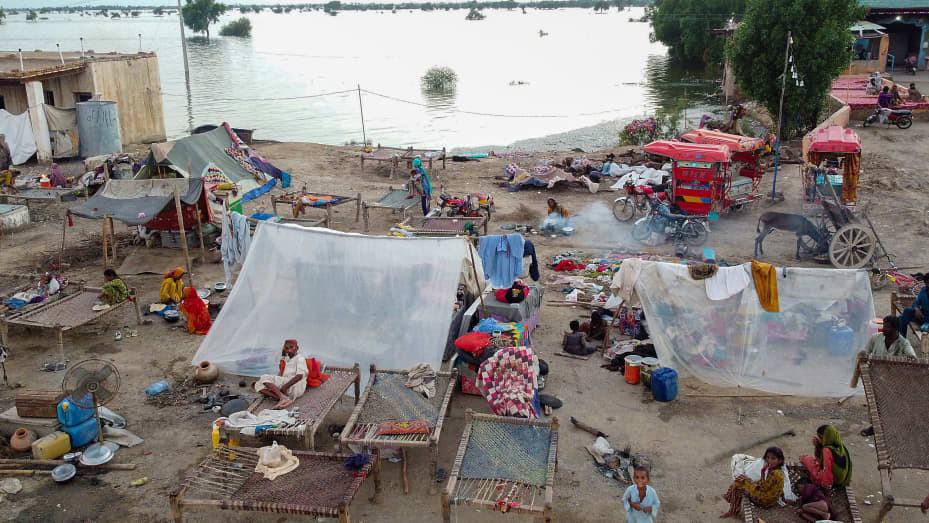 This aerial photograph taken on September 1, 2022 shows flood-affected people taking refuge in tents after heavy monsoon rains in Dera Allah Yar town of Jaffarabad district, Balochistan province. - Monsoon rains have submerged a third of Pakistan, claiming at least 1,190 lives since June and unleashing powerful floods that have washed away swathes of vital crops and damaged or destroyed more than a million homes.