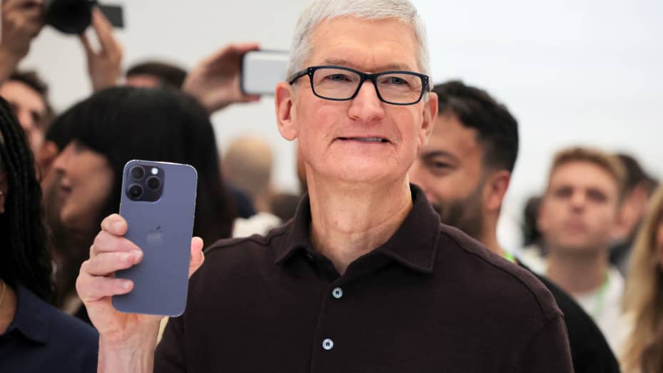 Apple CEO Tim Cook holds the new iPhone 14 at an Apple event at their headquarters in Cupertino, California, September 7, 2022.