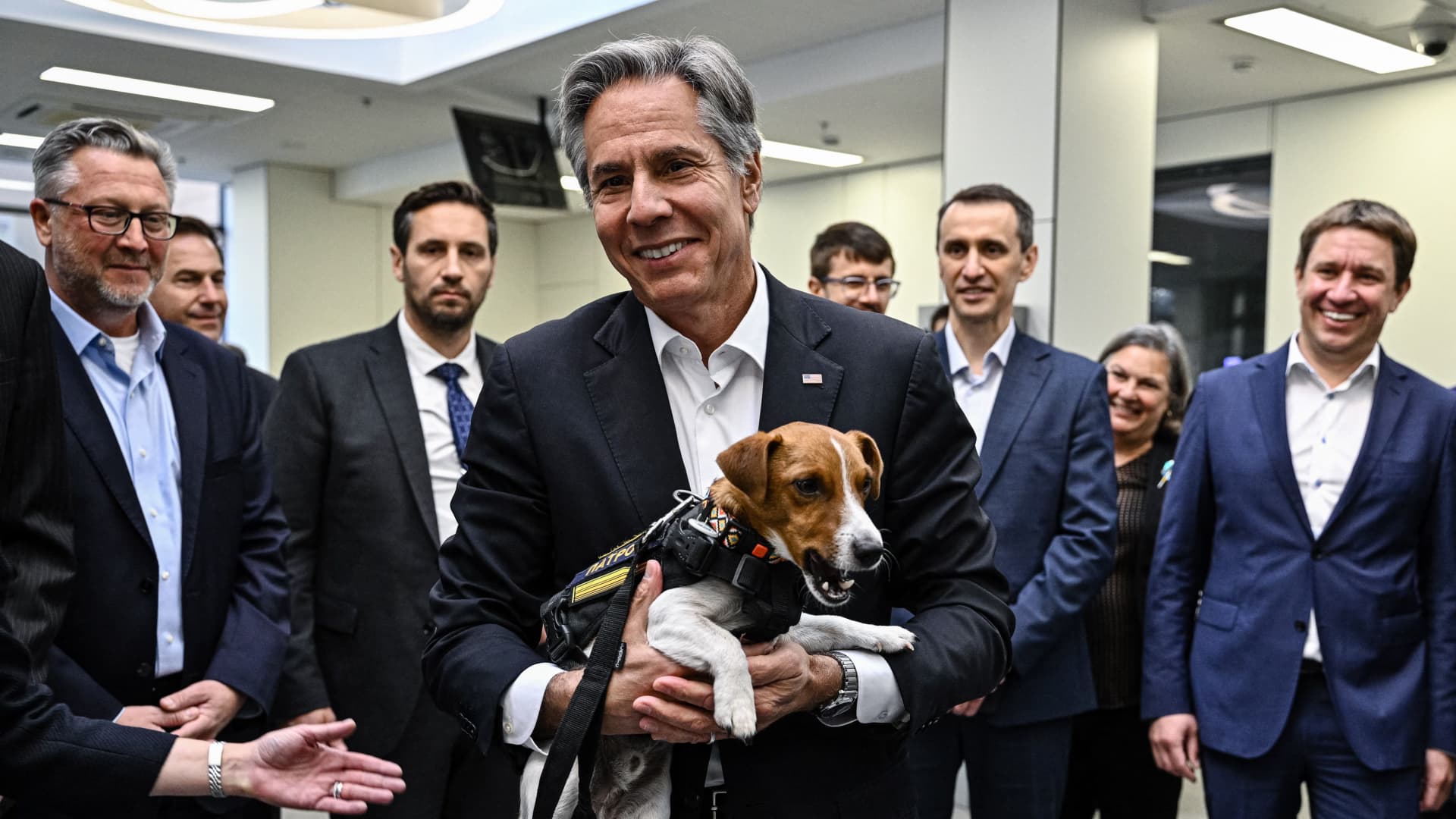 US' Secretary of State Antony Blinken (C) holds landmine sniffer dog, Jack Russell Terrier Patron during his visit at a children's hospital in Kyiv on September 8, 2022. Images)