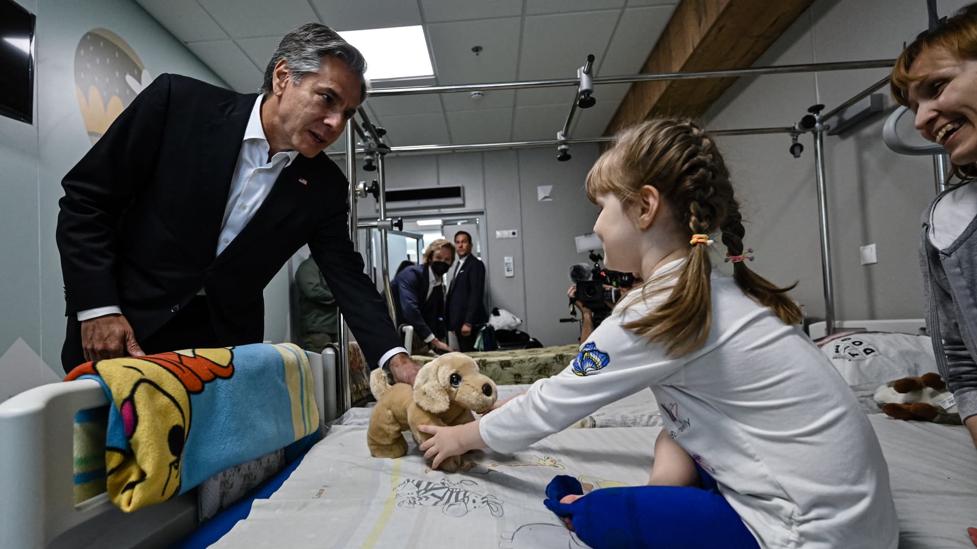US' Secretary of State Antony Blinken gives a gift to Marina, 6, from Kherson region, during his visit at a children's hospital in Kyiv on September 8, 2022.
