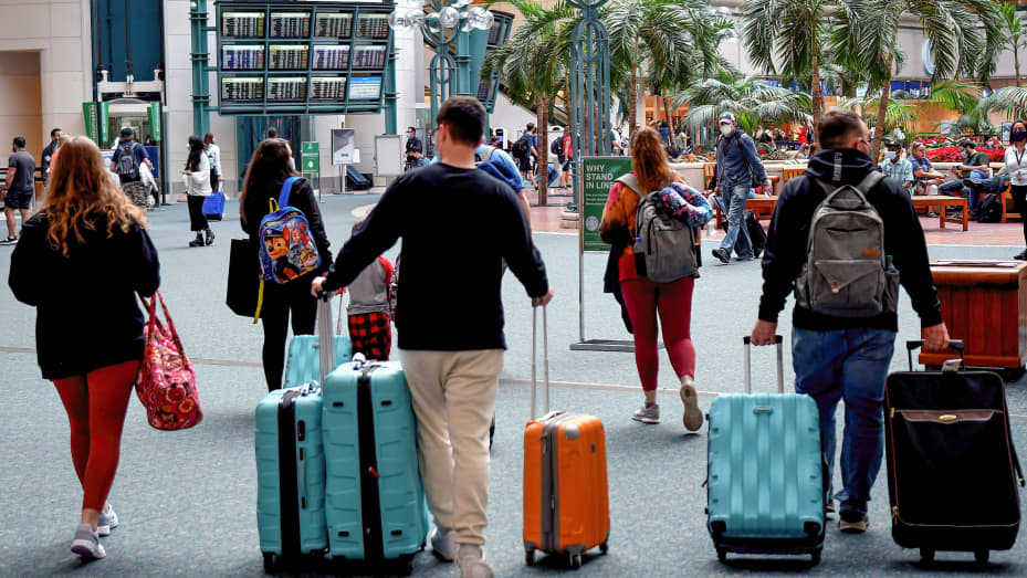 Travelers make their way through Orlando International Airport on New Year's weekend, despite thousands of flight cancellations and delays across United States.