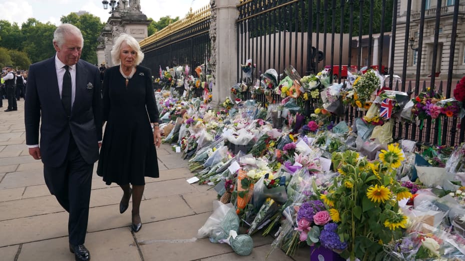 Britain's King Charles III and Britain's Camilla, Queen Consort view floral tributes left outside of Buckingham Palace in London, on September 9, 2022, a day after Queen Elizabeth II died at the age of 96.