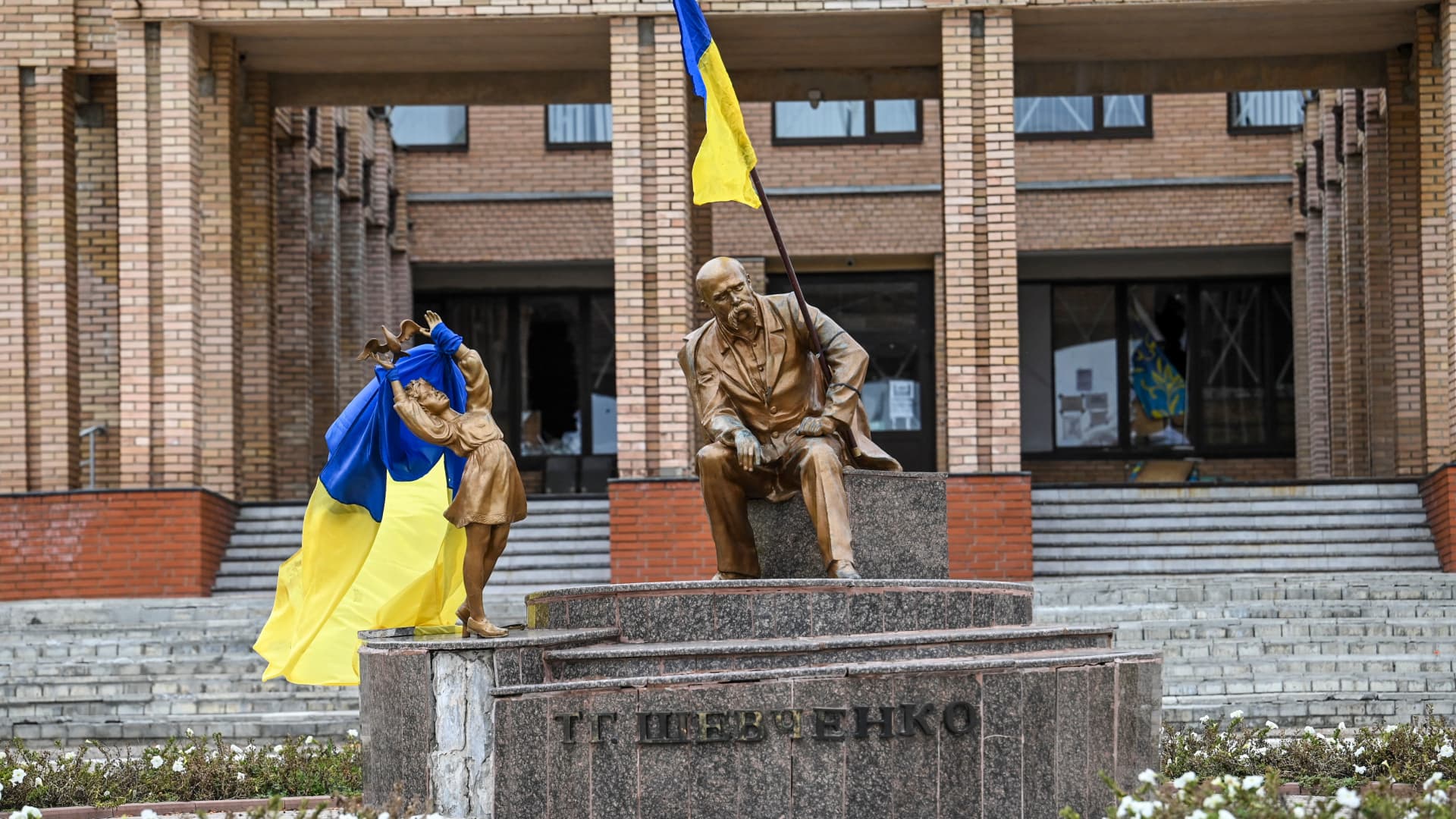 Ukrainian flags placed on statues in a square in Balakliya, Kharkiv region, on Sept. 10 , 2022.