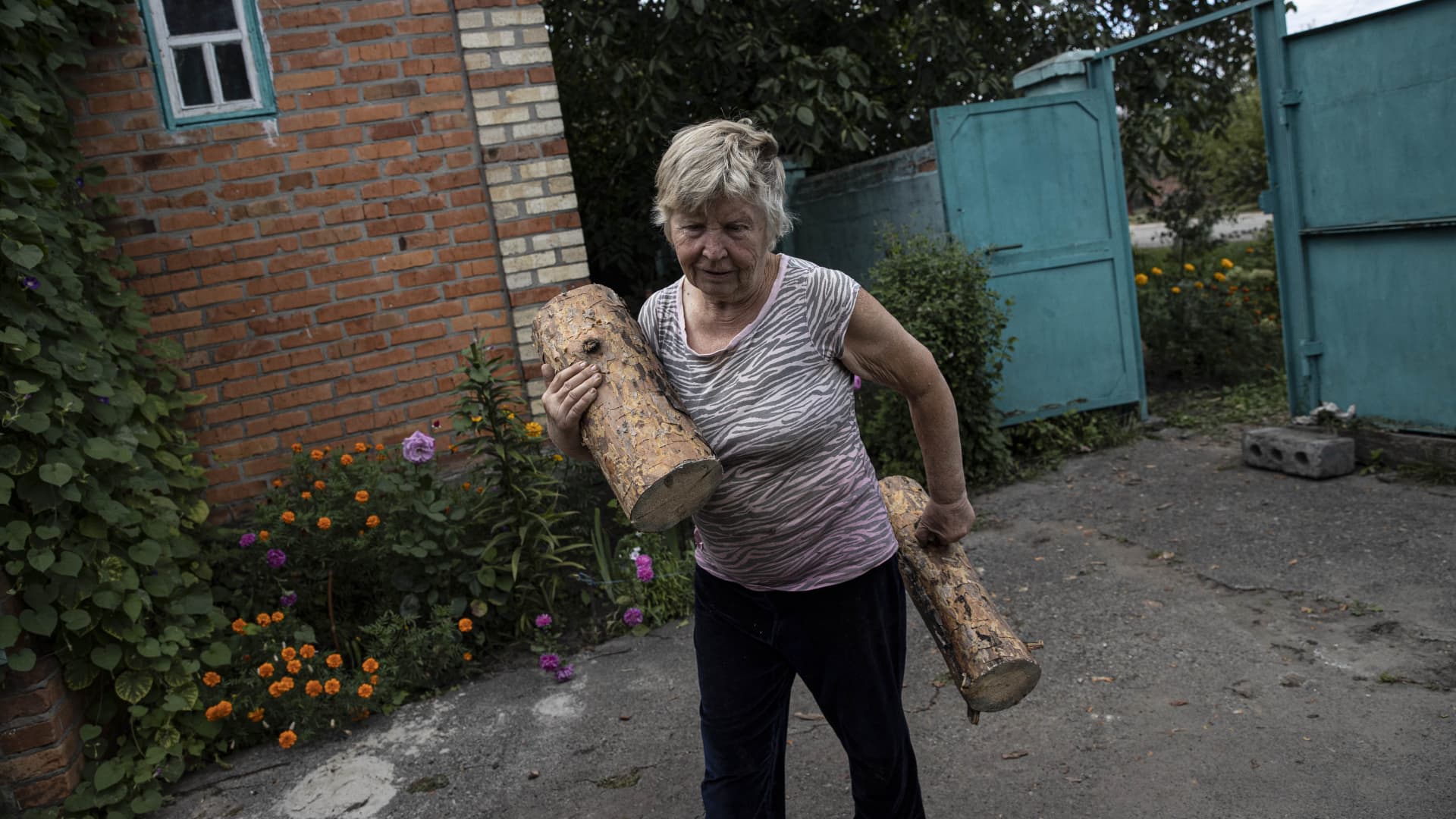 A Ukrainian woman prepares for the cold winter and stocking up on firewood in Kharkiv, Ukraine, September 13, 2022. 