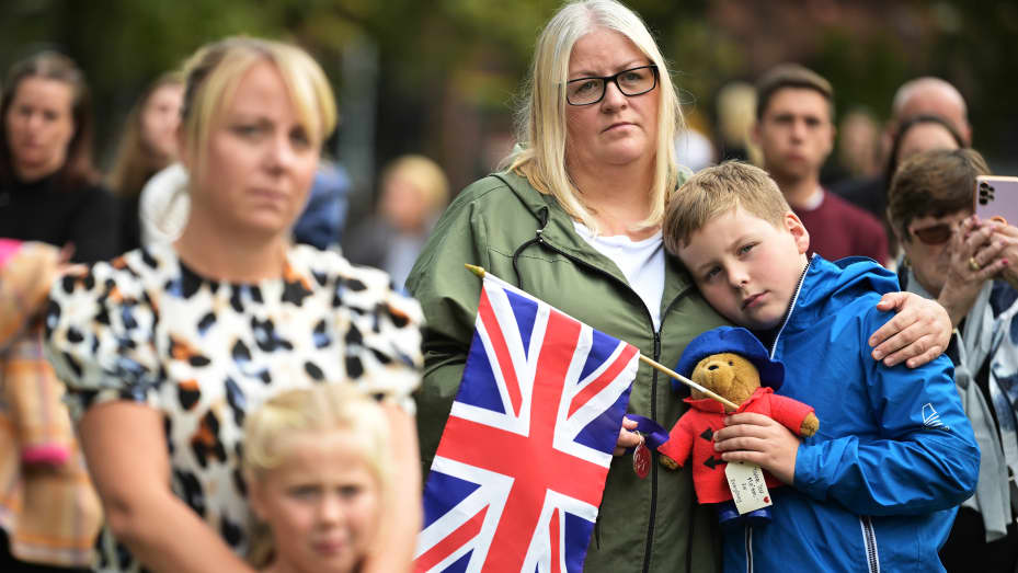 BELFAST, NORTHERN IRELAND - SEPTEMBER 19: A young boy is comforted by his mother as crowds of people gather to watch the funeral of Her Majesty Queen Elizabeth II on a screen in the grounds of Belfast city hall on September 19, 2022 in Belfast, United Kingdom. Elizabeth Alexandra Mary Windsor was born in Bruton Street, Mayfair, London on 21 April 1926. She married Prince Philip in 1947 and acceded to the throne of the United Kingdom and Commonwealth on 6 February 1952 after the death of her Father, King Geo