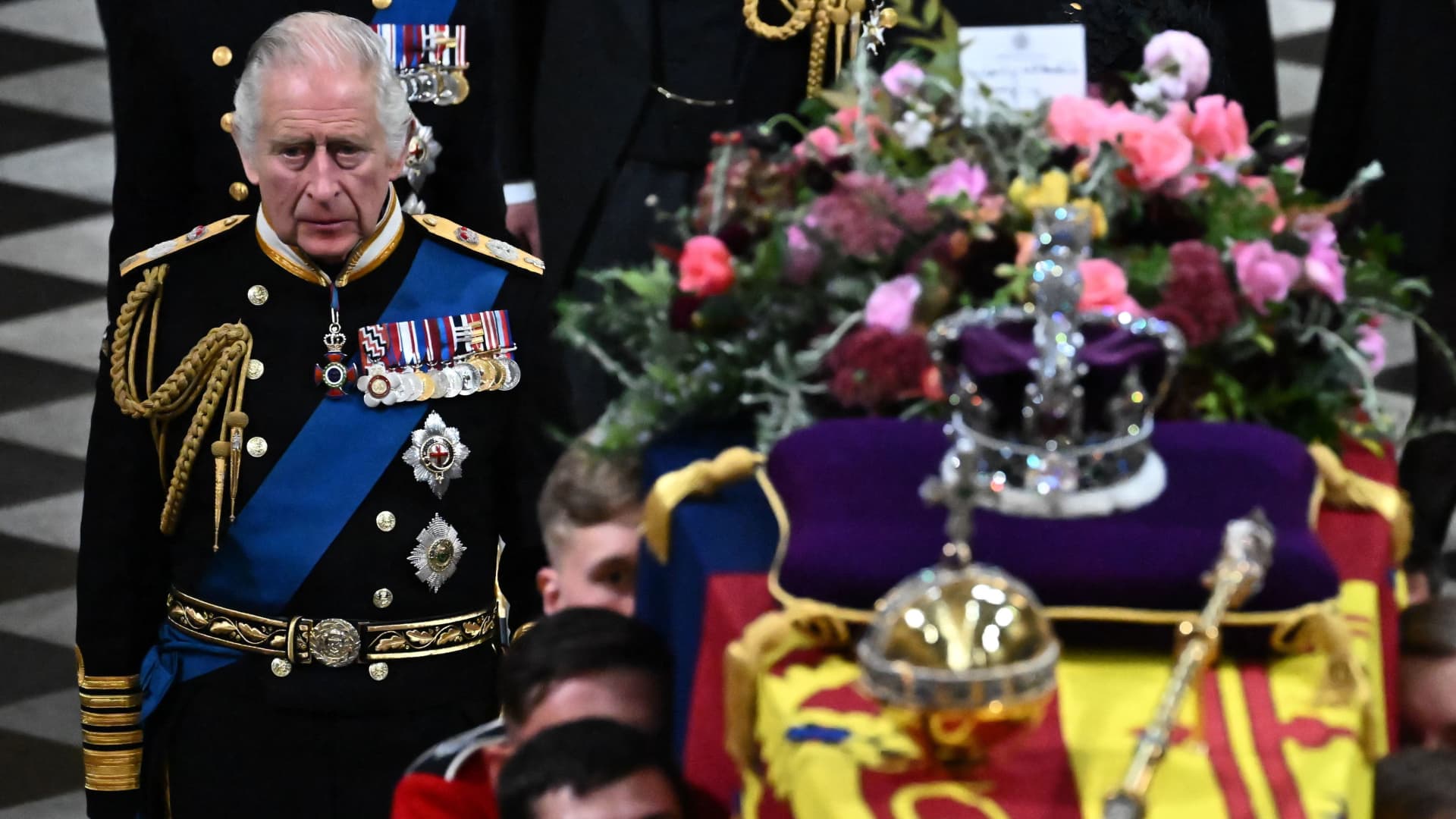 Britain's King Charles III (L) walks beside The coffin of Queen Elizabeth II, draped in a Royal Standard and adorned with the Imperial State Crown and the Sovereign's orb and sceptre as it leaves the Abbey at the State Funeral Service for Britain's Queen Elizabeth II, at Westminster Abbey in London on September 19, 2022.