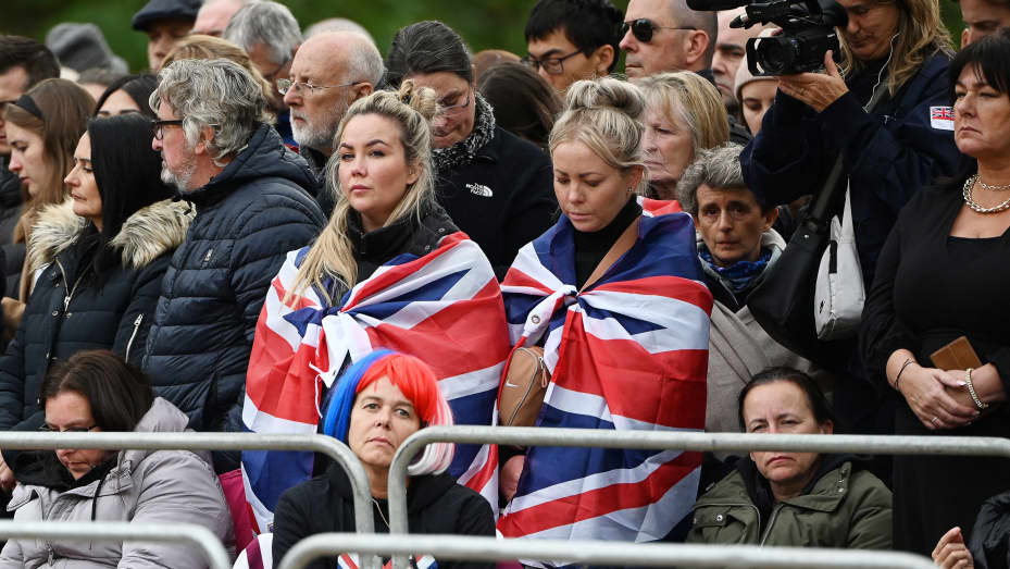 TOPSHOT - Members of the public wait for the passage of the coffin along the Procession Route in London on September 19, 2022, during the State Funeral Service of Britain's Queen Elizabeth II. - Leaders from around the world attended the state funeral of Queen Elizabeth II. The country's longest-serving monarch, who died aged 96 after 70 years on the throne, was honoured with a state funeral on Monday morning at Westminster Abbey. (Photo by Paul ELLIS / POOL / AFP) (Photo by PAUL ELLIS/POOL/AFP via Getty Im