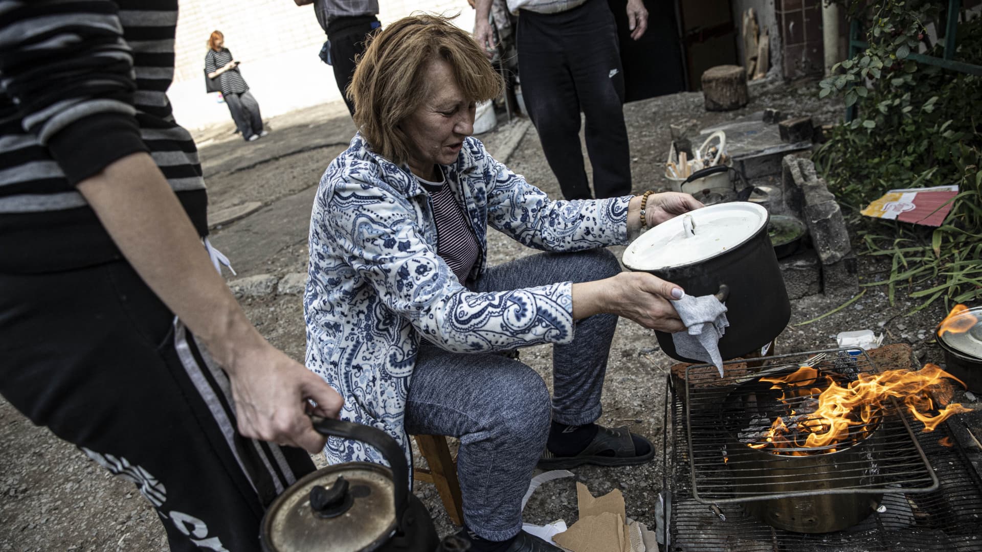 Ukrainians cook their meal on a wood fire outside their homes after Russian Forces withdrawal from Izium as Russia-Ukraine war continues in Izium, Kharkiv Oblast, Ukraine on September 18, 2022.