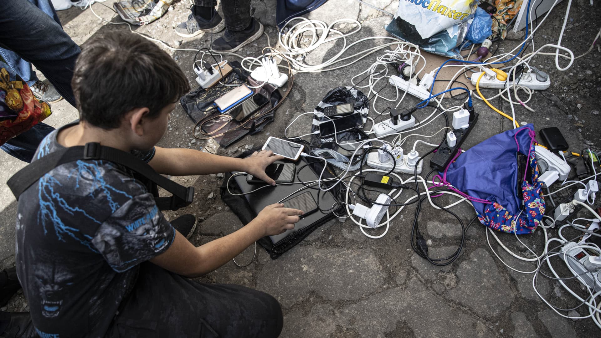 Ukrainian citizens charge their mobile phones and tablets from a generator supplied by Ukrainian soldiers after Russian Forces withdrawal from Izium as Russia-Ukraine war continues in Izium, Kharkiv Oblast, Ukraine on September 18, 2022.