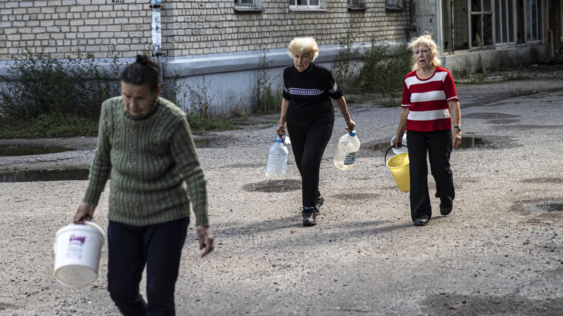Ukrainian citizens carry bottles and buckets to receive clean water delivered by volunteer organizations after Russian Forces withdrawal from Izyum as Russia-Ukraine war continues in Izium, Kharkiv Oblast, Ukraine on September 18, 2022.