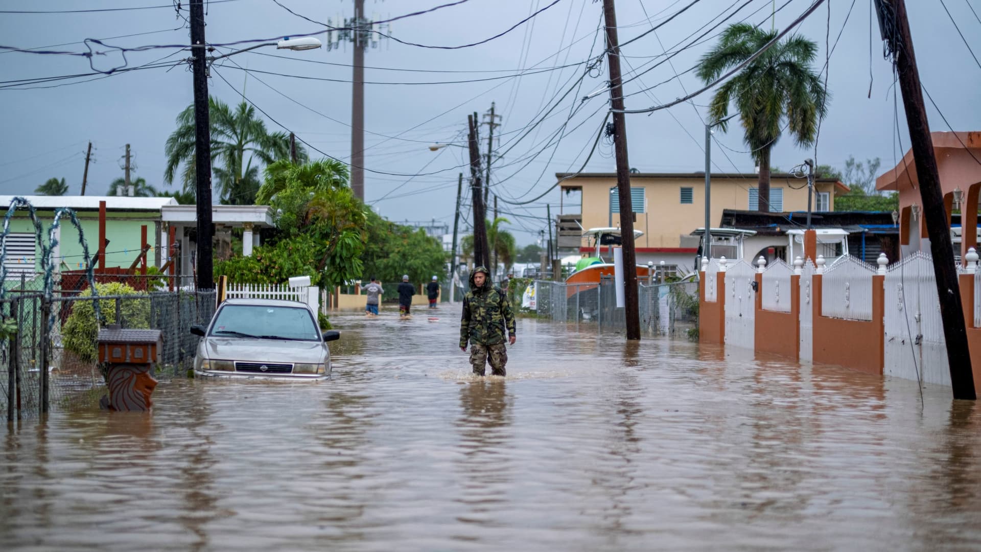 A member of the Puerto Rico National Guard wades through water in search for people to be rescued from flooded streets in the aftermath of Hurricane Fiona in Salinas, Puerto Rico September 19, 2022.