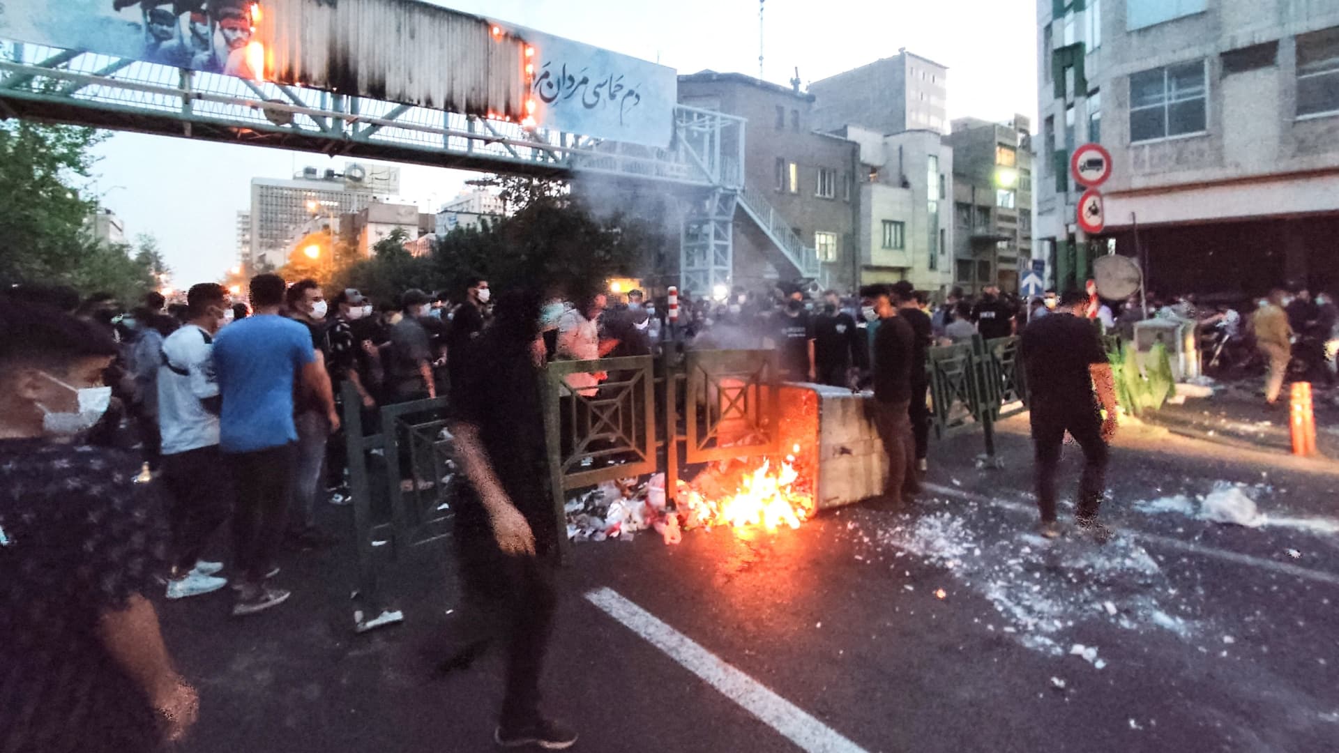 A picture obtained by AFP outside Iran on September 21, 2022, shows Iranian demonstrators burning a rubbish bin in the capital Tehran during a protest for Mahsa Amini, days after she died in police custody. -