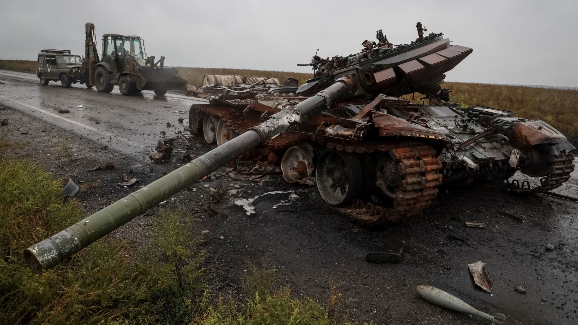 A destroyed Russian tank is seen as Ukrainian serviceman rides a tractor and tows a Russian military vehicle, amid Russia's invasion on Ukraine, near the village of Dolyna in Kharkiv region, Ukraine September 23, 2022.