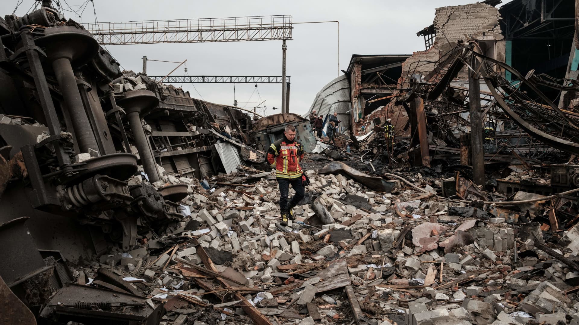 A firefighter walks through rubble at a railway yard of the freight railway station in Kharkiv, which was partially destroyed by a missile strike, amid the Russian invasion of Ukraine on Sept. 28, 2022.