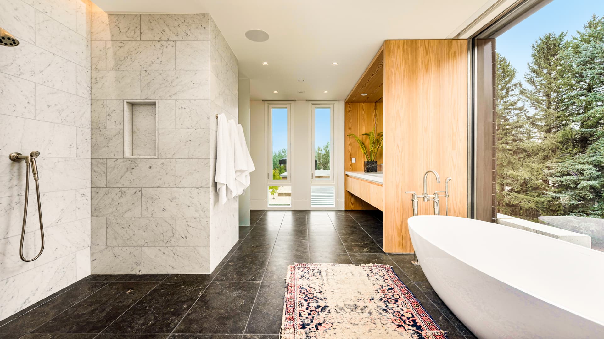The second story spa-like primary bath clad in Carrera marble.