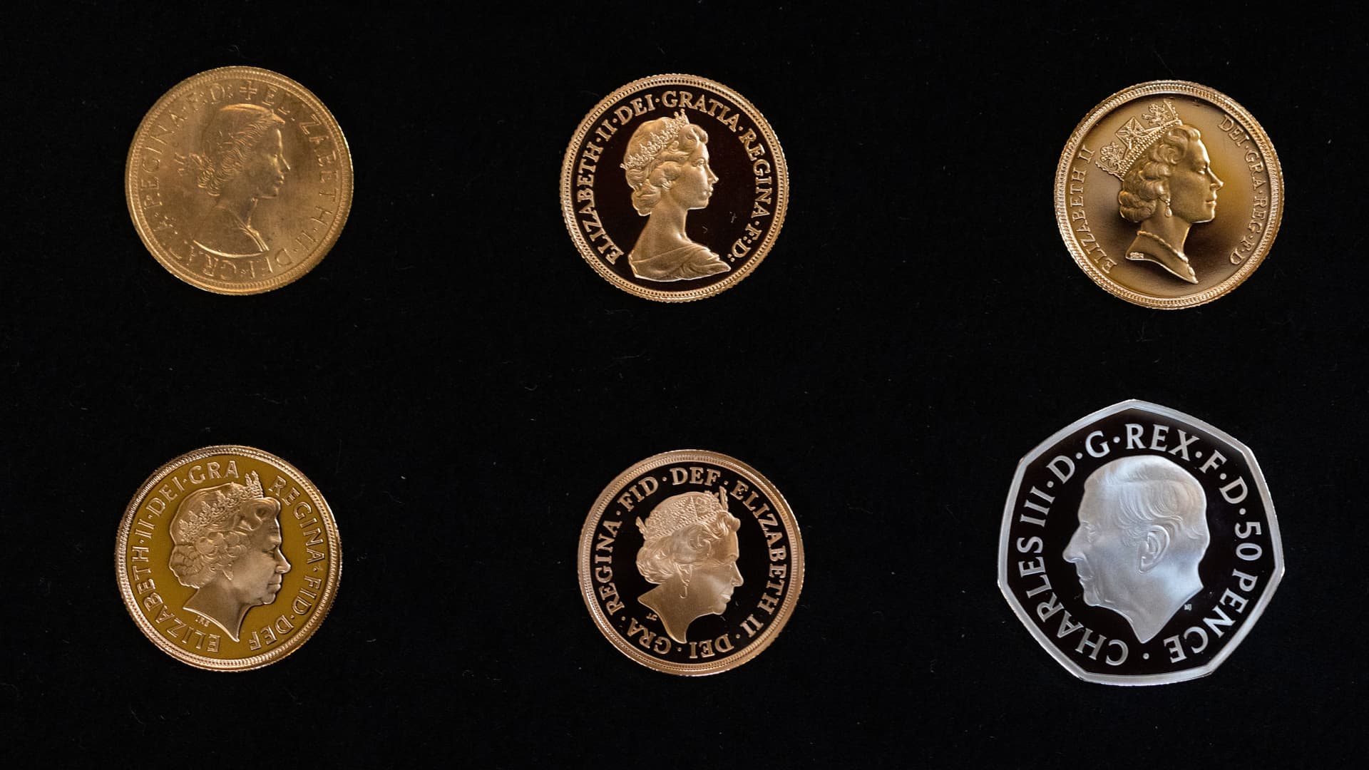 A display of coins showing the five versions of Queen Elizabeth II's head used over her lifetime, and the new King Charles III's head on a new 50 pence coin