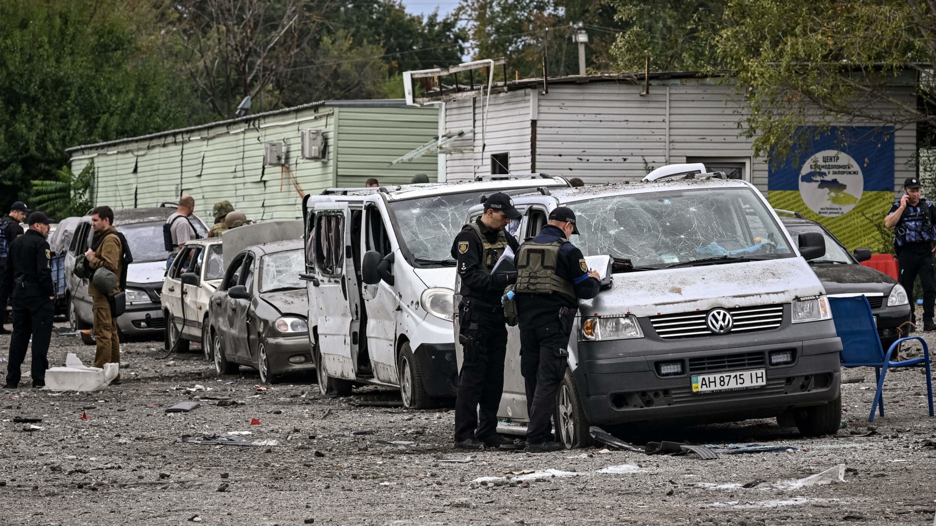 EDITORS NOTE: Graphic content / Ukrainian policemen check cars damaged by a missile strike on a road near Zaporizhzhia on September 30, 2022, amid the Russian invasion of Ukraine. 