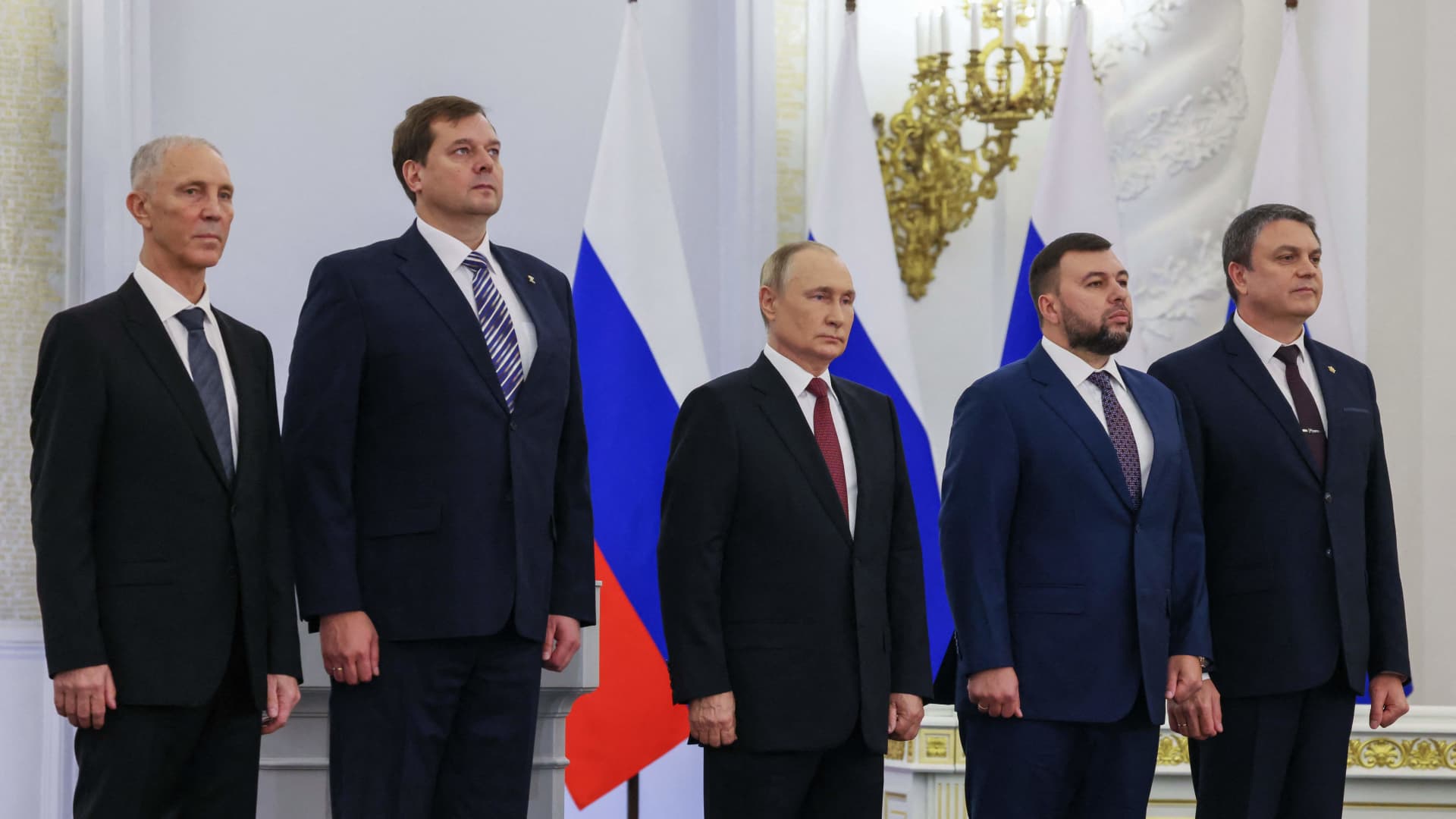 (From left) The Moscow-appointed heads of Kherson region Vladimir Saldo and Zaporizhzhia region Yevgeny Balitsky, Russian President Vladimir Putin, Donetsk separatist leader Denis Pushilin and Luhansk separatist leader Leonid Pasechnik listen to the Russian national anthem after signing treaties formally annexing four regions of Ukraine Russian troops occupy, at the Kremlin in Moscow on Sept. 30, 2022.