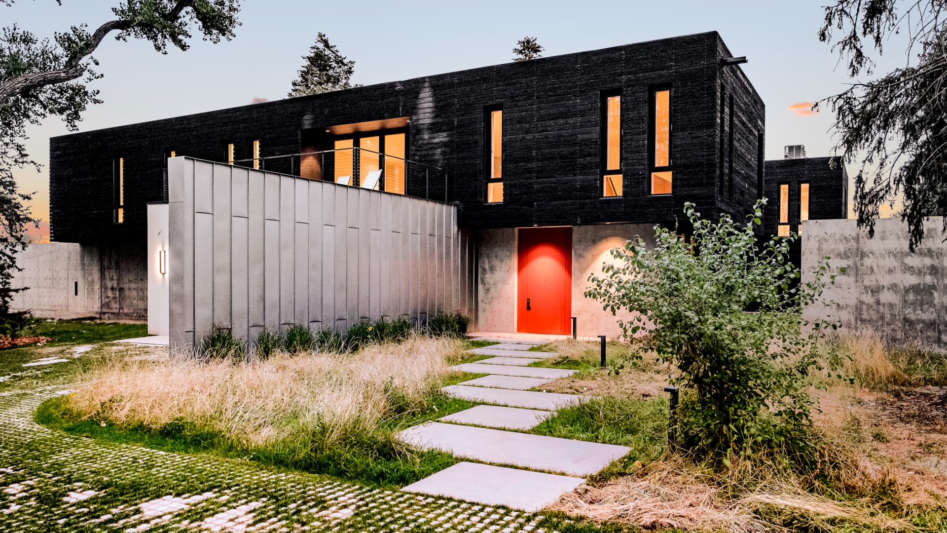 The modern home's facade blends charred-wood, concrete and glass.