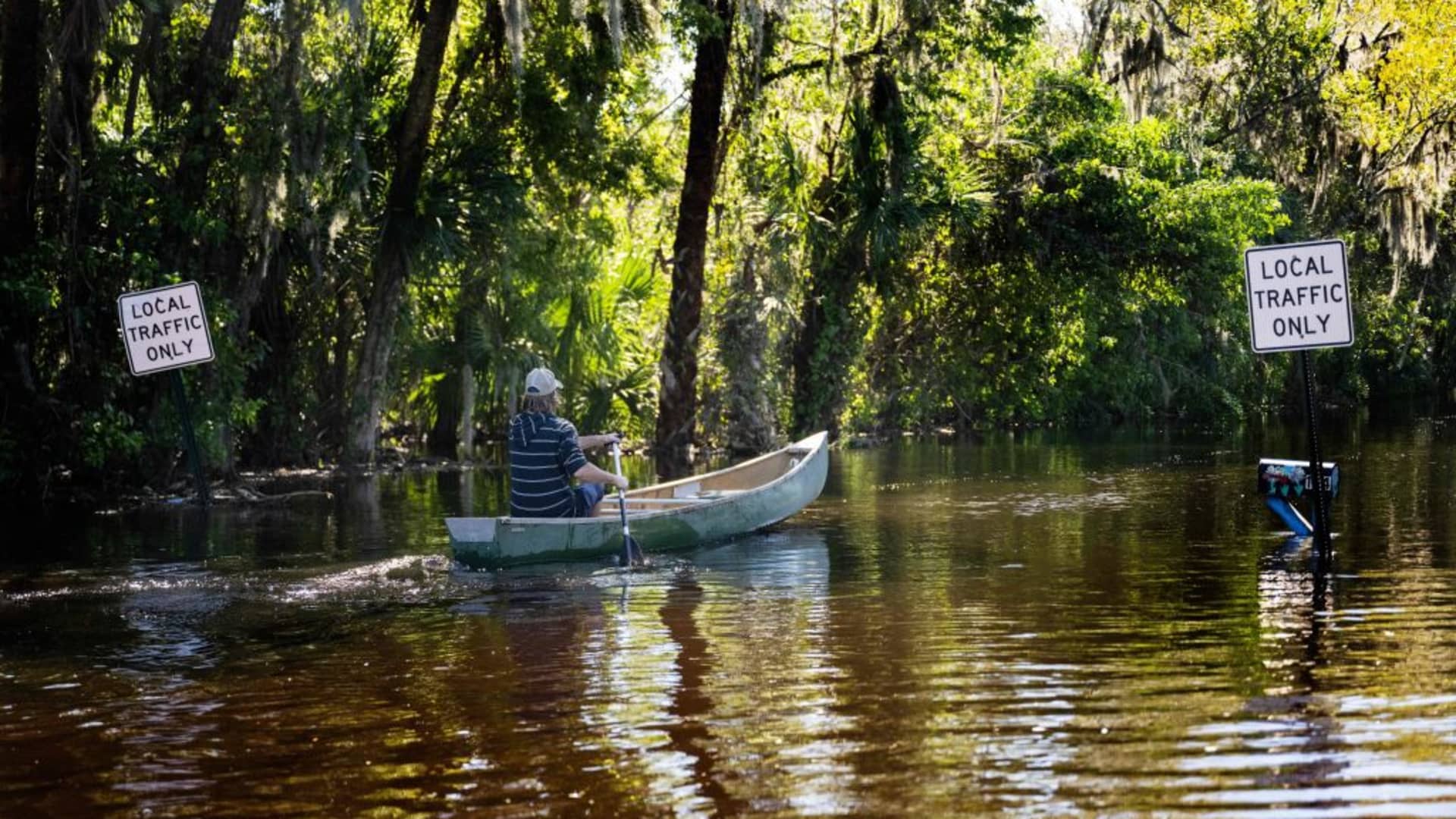 A man paddles a canoe through a flooded neighborhood in New Smyrna Beach, Florida, on September 30, 2022, after Hurricane Ian slammed the area.