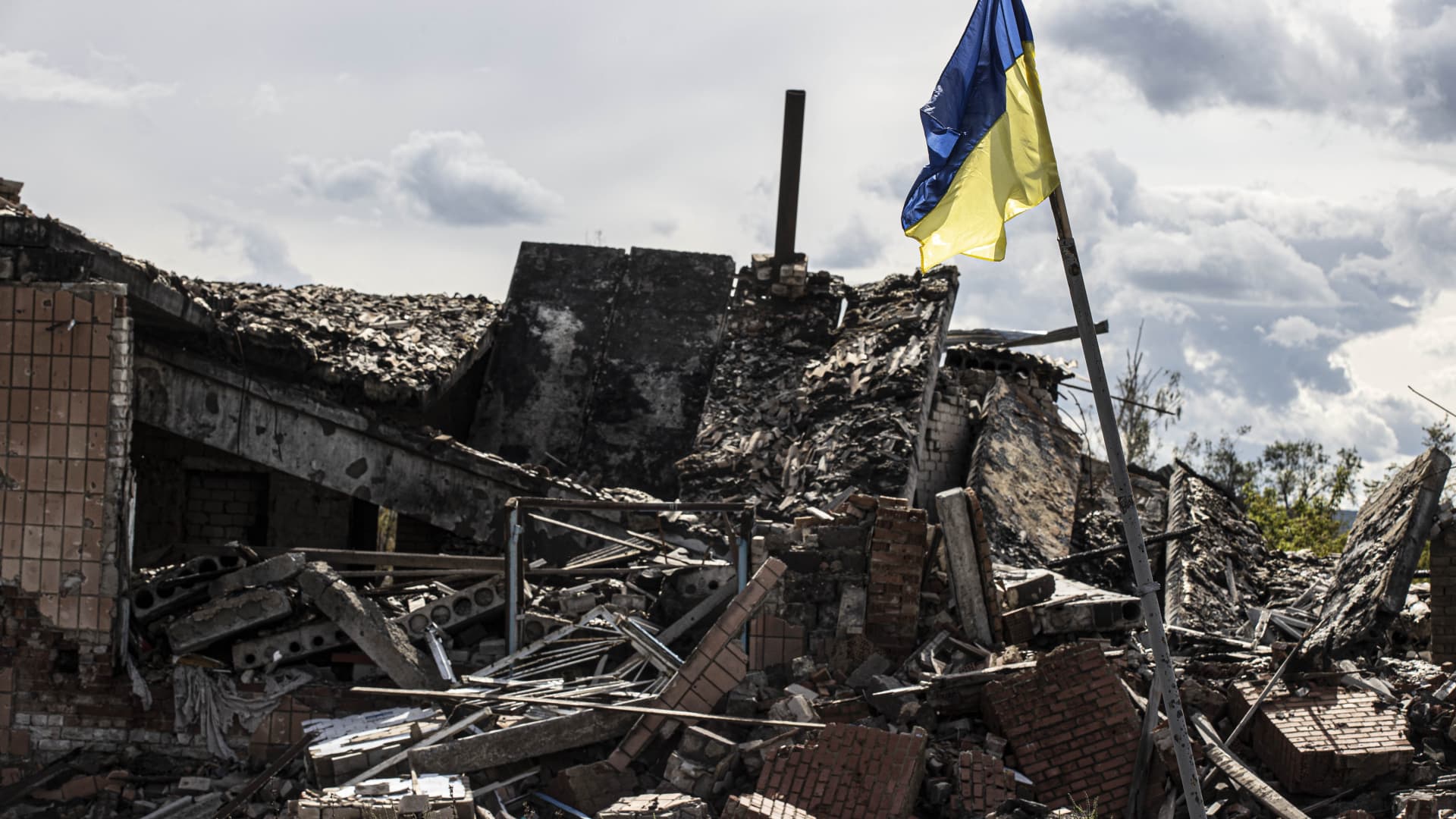 A Ukrainian flag waves in a residential area heavily damaged in the village of Dolyna in Donetsk Oblast, Ukraine after the withdrawal of Russian troops on September 24, 2022.