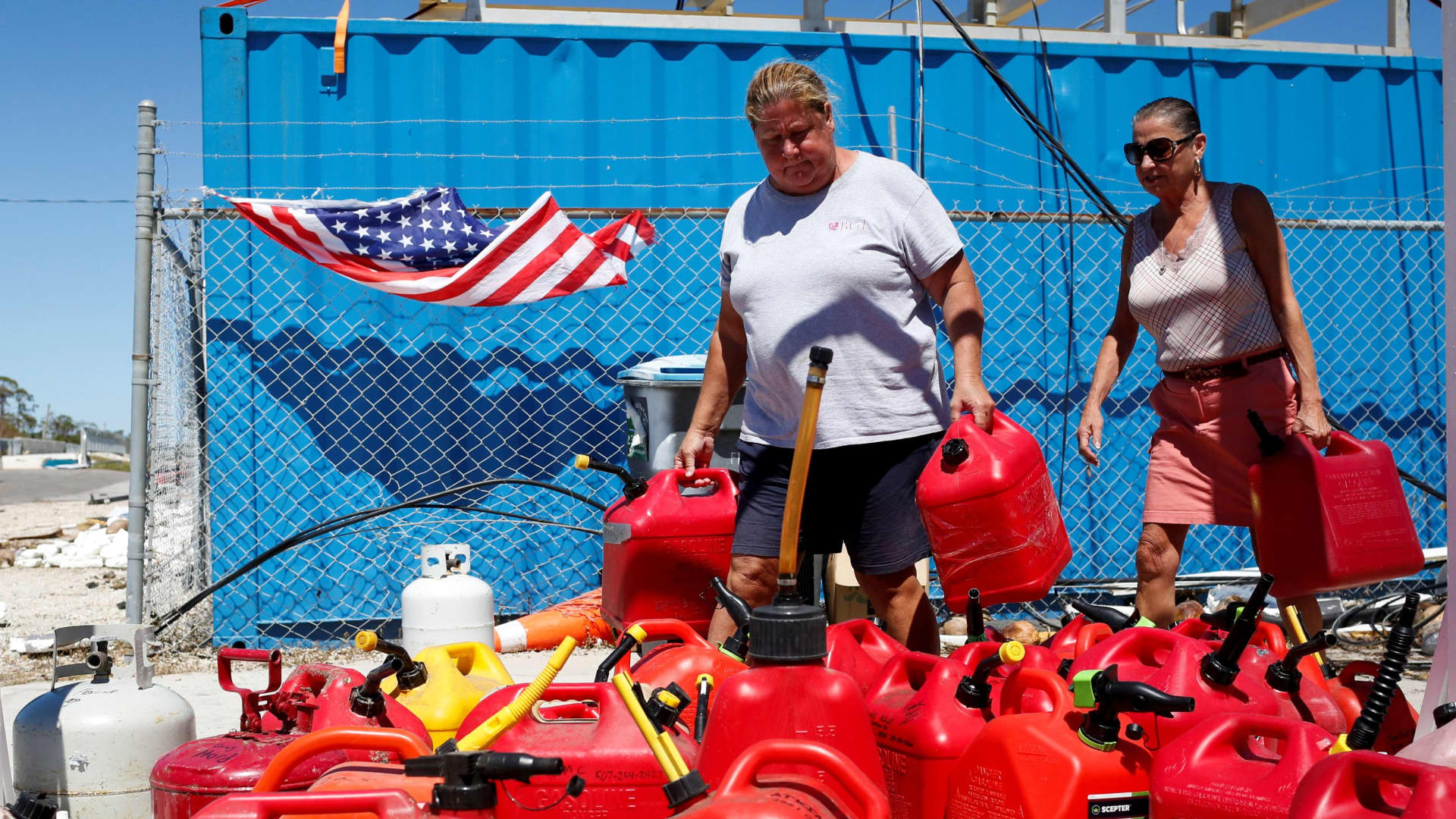 People carrying gas containers look for gas at a distribution center organized by the community after Hurricane Ian caused widespread destruction in St James City, Florida, U.S., October 2, 2022. 