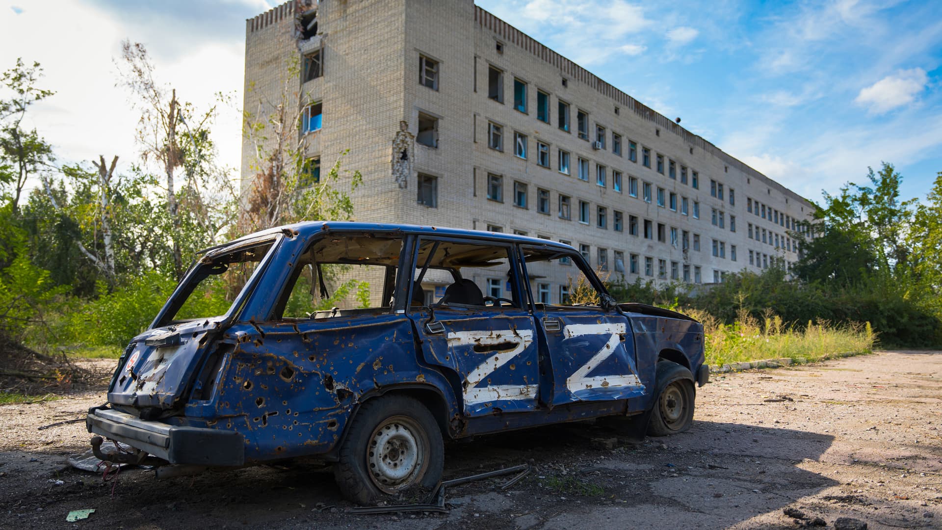 A damaged car, which was carjacked by Russian soldiers, pictured in front of a damaged hospital building on Sept. 27, 2022, in Vysokopillia, Ukraine.