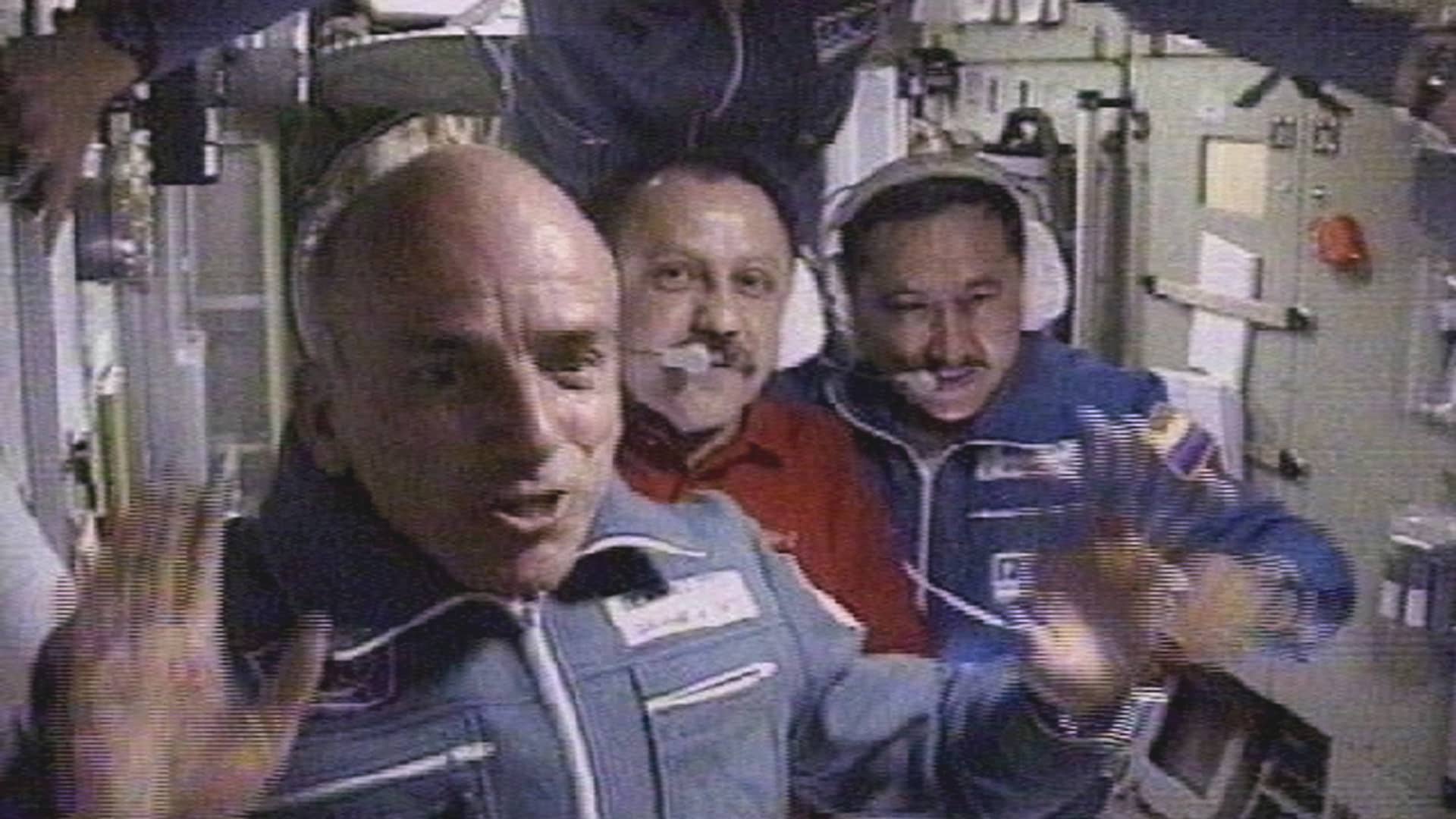 The world's first space tourist Dennis Tito waves in front of the International Space Station crew shortly after his arrival to the station April 30, 2001 in this image from television.