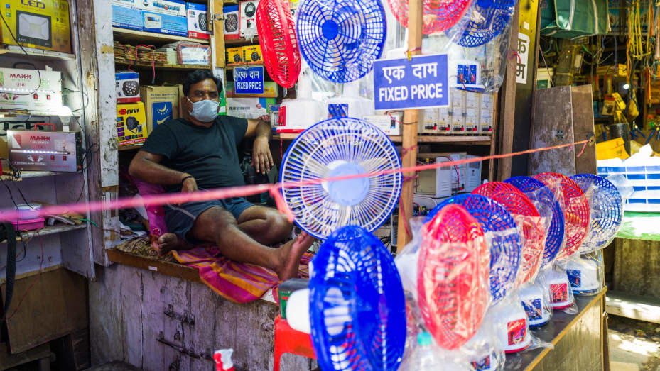 En mann venter på kunder som viser vifter i butikken hans midt i stigende temperaturer i New Delhi 27. mai 2020. - India visner under en hetebølge, med temperaturen på steder som når 50 grader Celsius (122 grader Fahrenheit) og hovedstaden holder på med det varmeste mai om nesten to tiår.